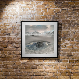 Winter mountain shoreline framed by a small reflective tidal pool