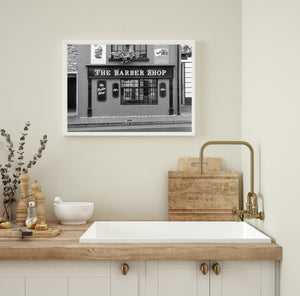 Monochrome storefront with flower boxes above a barber shop sign