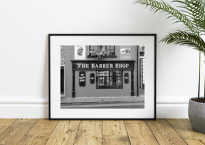 Decorative barber signage beside a broad multi-pane window