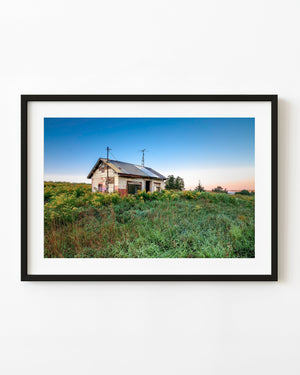 Small abandoned house amid green overgrowth