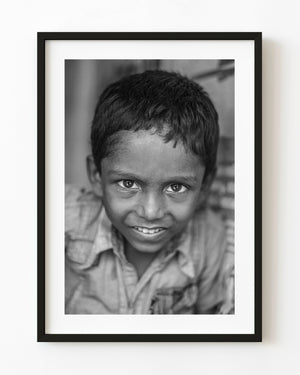 Smiling Indian boy in a black and white street portrait