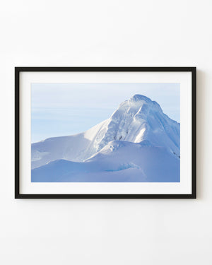 Snow-covered Antarctic mountain with soft blue shadows