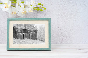 Pitched metal roof and timber barn wall in a snowy landscape