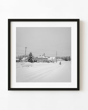 Snowmobiler on a Canadian village road in black and white
