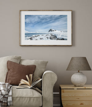 Wide Antarctic landscape with ice-covered rocks and high streaked clouds
