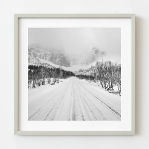 Snowy road to Norwegian peaks black and white