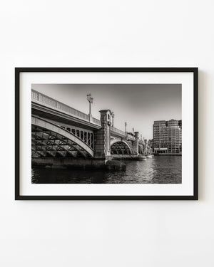 Southwark Bridge arches over the Thames in black and white