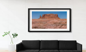 Southwestern badlands and a prominent red desert butte.