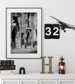 Black and white architectural detail of an arched doorway and iron balcony.