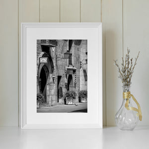 Textured Spanish stone walls, hanging signs and potted plants.