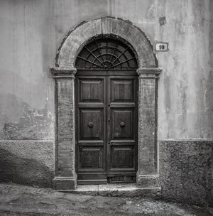 Paneled Italian doorway with a semicircular iron fanlight in Spoleto.