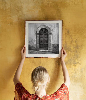 Historic Spoleto entrance framed by stone columns and an arched lintel.