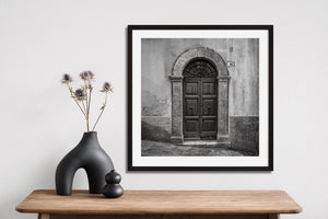 Spoleto doorway with carved wood panels and fan-shaped ironwork.