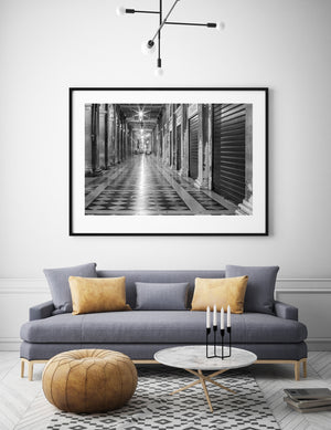 St Marks Square arcade with glowing lights and distant blurred figures.