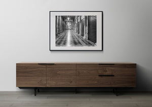 Geometric floor tiles lead through a quiet Venice colonnade in monochrome.