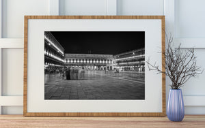 Venice night scene with cafe seating and brightly lit historic facades.