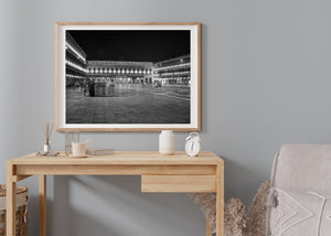 Black and white Venetian piazza with starburst lights and passing visitors.