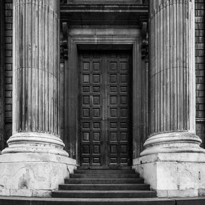 Massive columns frame a shadowed doorway at St Pauls Cathedral.