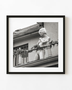 Black and white Toronto rooftop mannequin wearing a knitted hat behind a decorated railing.
