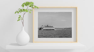 A Staten Island Ferry crosses the harbor with a foaming wake.