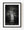 Illuminated Statue of Liberty at night against dark clouds in black and white.