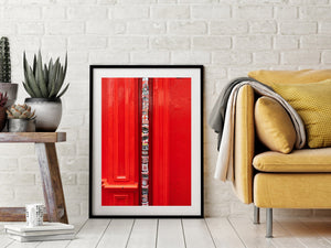 Urban colour photograph of a sticker-covered pipe framed by red mouldings.