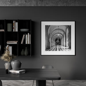 Long architectural perspective through a corridor of statues and stone columns.