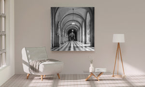 Monochrome arched gallery with bright lanterns and alternating floor tiles.