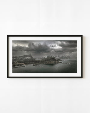 Heavy storm clouds above Lofoten coastal mountains and dark sea.