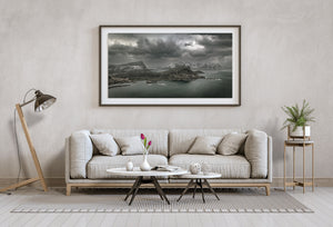 Wide northern coastal view with mountain ridges, small islands and low storm clouds.