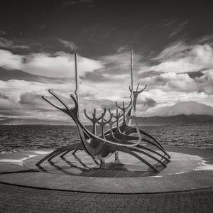 Skeletal boat-shaped metal sculpture beside the sea in Reykjavik.