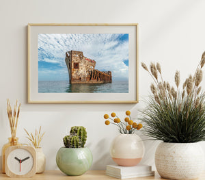 Rusted shipwreck against blue ocean