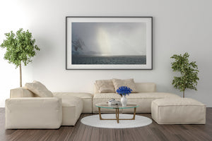 Wide polar landscape with shadowed ice slopes and a luminous storm.