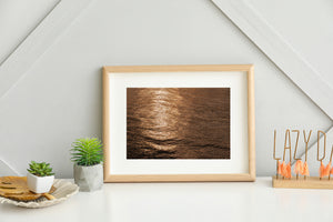 Bronze colored light dancing across open sea