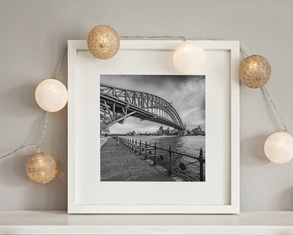 Iconic bridge and boardwalk under wispy clouds in Sydney