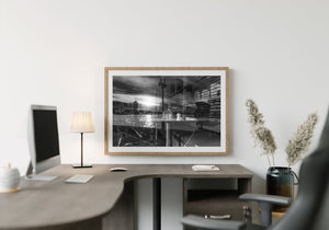 Monochrome window study combines harbour light, interior furniture and glass reflections.
