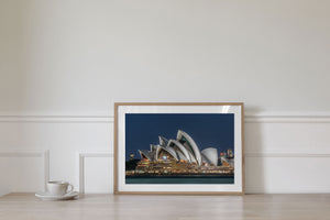 Warm building lights contrast with cool evening tones around the Sydney Opera House.