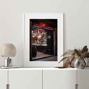 Colour photograph of a Barcelona tavern with wooden barrels and an open dark door.