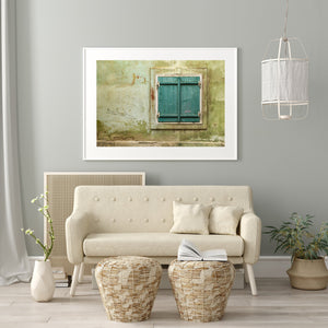 Time-worn window set in a wall with peeling paint, embodying stories of the past.