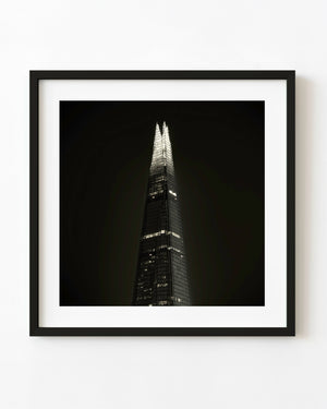 The Shard illuminated against a dark London sky in toned monochrome.