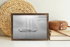 Black and white seascape with a three-masted vessel and broad open sky.
