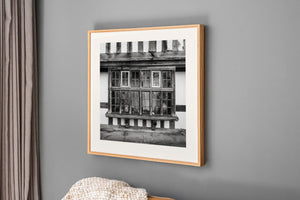 Historic Rye window with worn wooden frames and pale plaster panels.