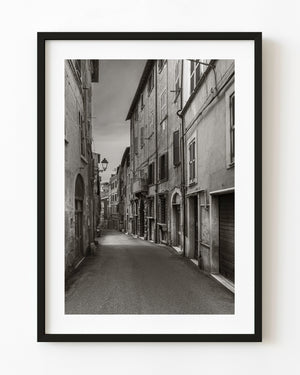 Narrow Tivoli street lined with shuttered facades in black and white