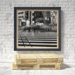 Ingelijste zwart-witte stadsprint op een bakstenen muur met een houten pallet aan de onderkant.