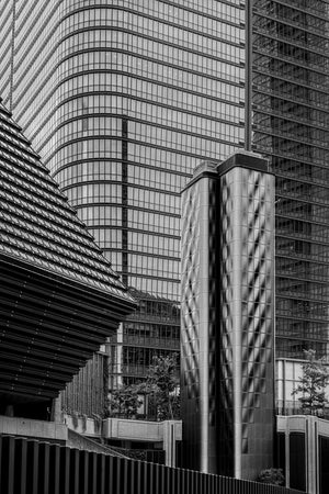 Reflective metal structures against gridded glass facades in Tokyo