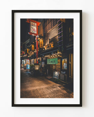 Warm lanterns and restaurant signs along a Tokyo izakaya lane at night