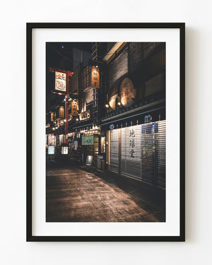 Warmly lit Tokyo lantern street with closed restaurant shutters after midnight