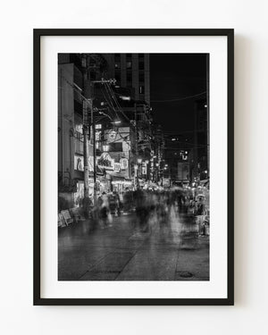 Motion-blurred crowd on a lantern-lit Tokyo street in black and white