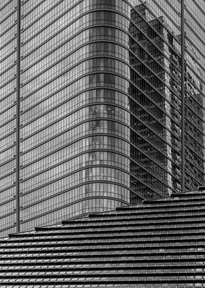 Traditional tiled roof beneath a modern Tokyo glass high-rise