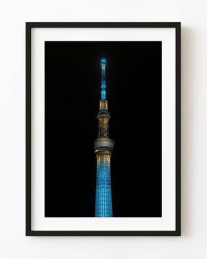 Tokyo Skytree illuminated in blue and gold against the night sky